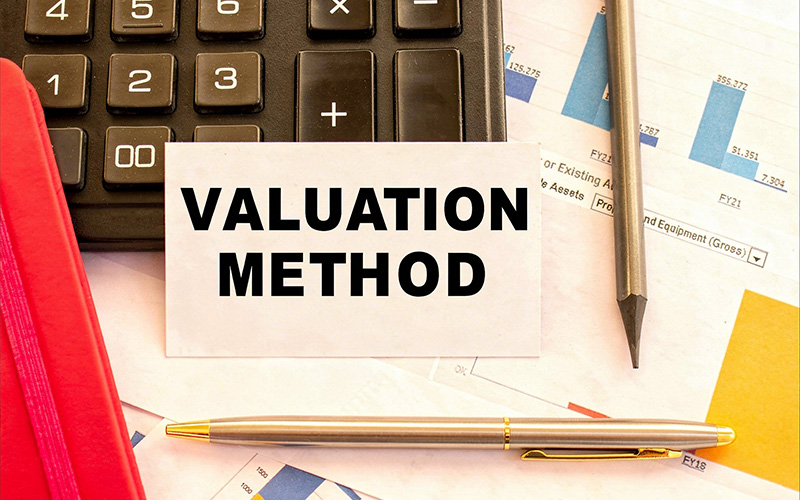 Card labeled valuation method resting on financial charts.