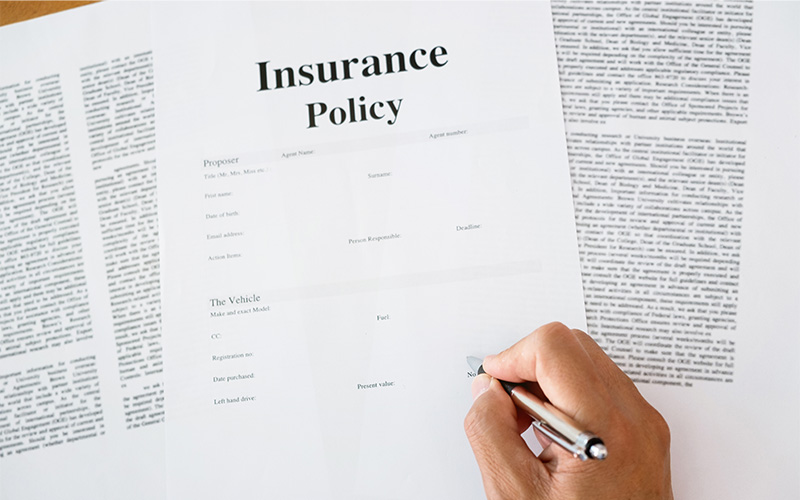 Hand signing an insurance policy document