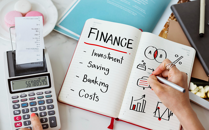 Person planning personal finance and insurance costs in a notebook.