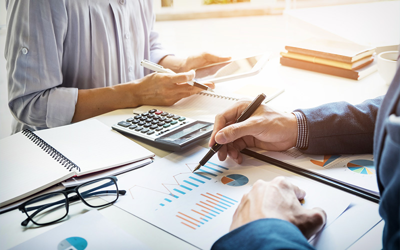 A financial advisor and a client reviewing bar charts